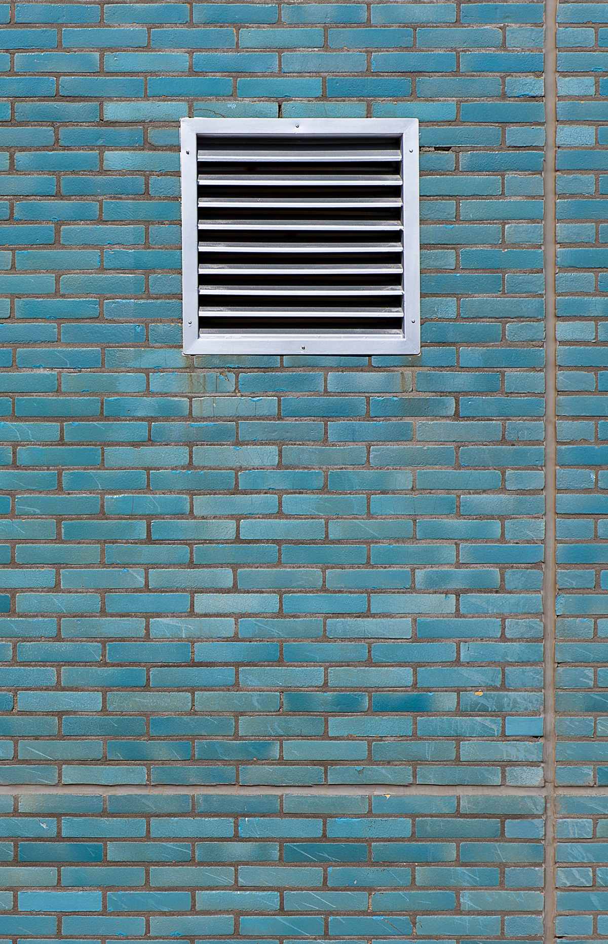 White air vent grille mounted on a blue painted brick wall White air vent grille mounted on a blue painted brick wall