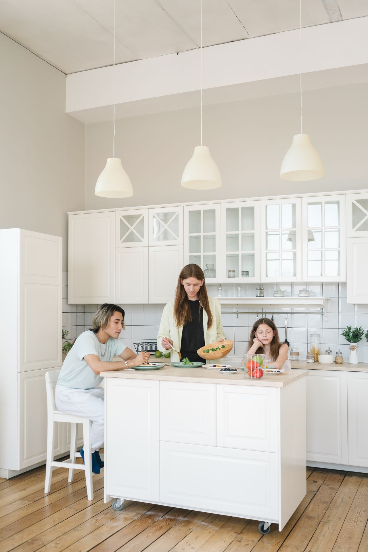 Family preparing food together in a bright, modern kitchen Family preparing food together in a bright, modern kitchen
