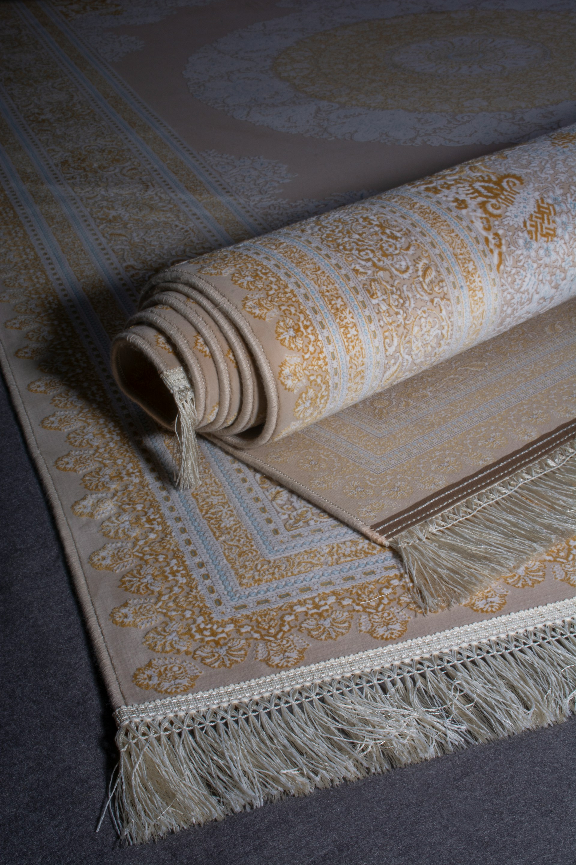Close-up of a rolled Persian-style area rug showing its fringe and patterned border