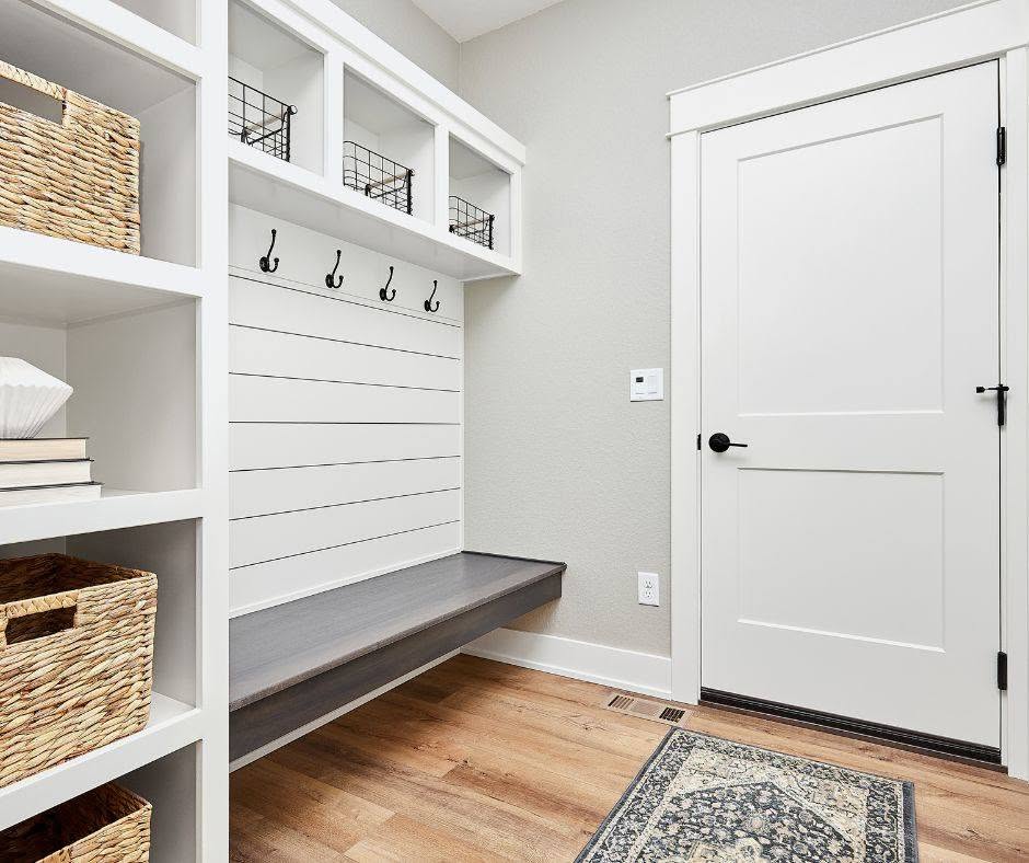 a white door with a bench and shelves