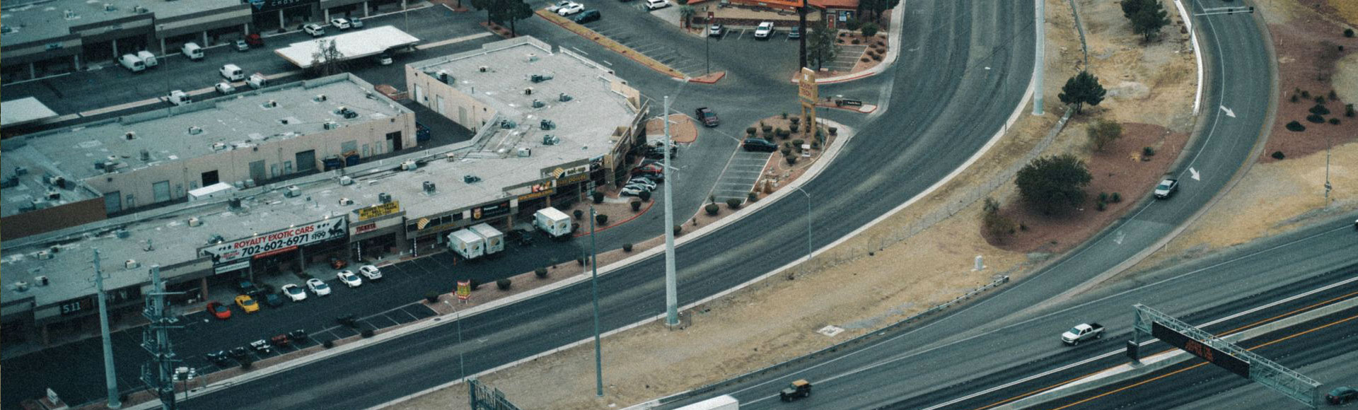 Aerial view of a commercial office complex and parking lot beside a freeway interchange Aerial view of a commercial office complex and parking lot beside a freeway interchange
