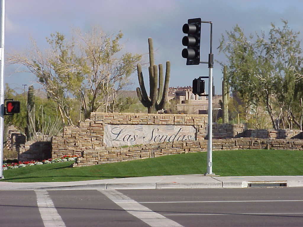 Las Sendas community entrance monument with a saguaro and boulders at a street corner Las Sendas community entrance monument with a saguaro and boulders at a street corner