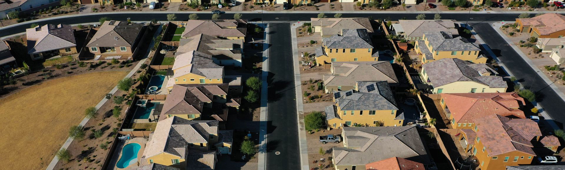 Aerial view of a Phoenix-area HOA neighborhood with tile roofs, streets, and a backyard pool Aerial view of a Phoenix-area HOA neighborhood with tile roofs, streets, and a backyard pool