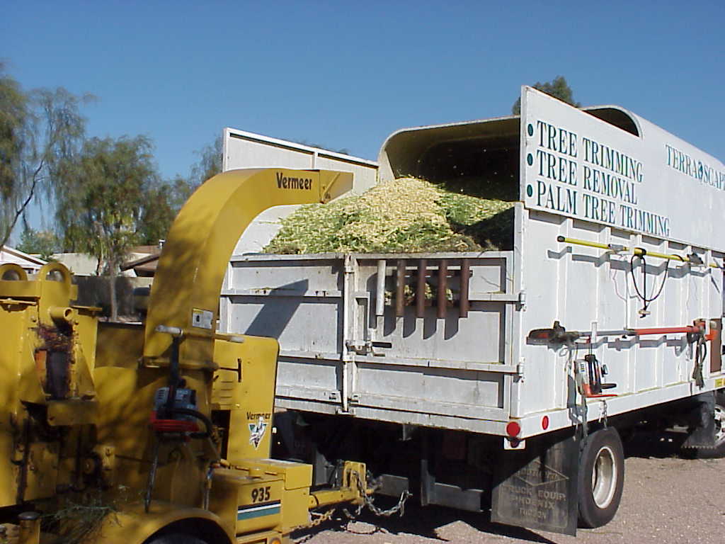 TerraPro chip truck heaped with fresh wood chips at the end of a tree trimming job TerraPro chip truck heaped with fresh wood chips at the end of a tree trimming job