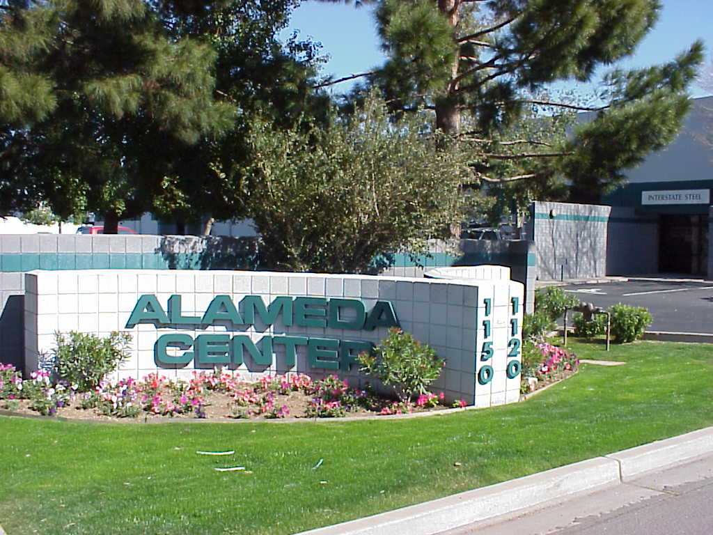 Alameda Center monument sign set in a flower bed beside a trimmed lawn and sidewalk Alameda Center monument sign set in a flower bed beside a trimmed lawn and sidewalk