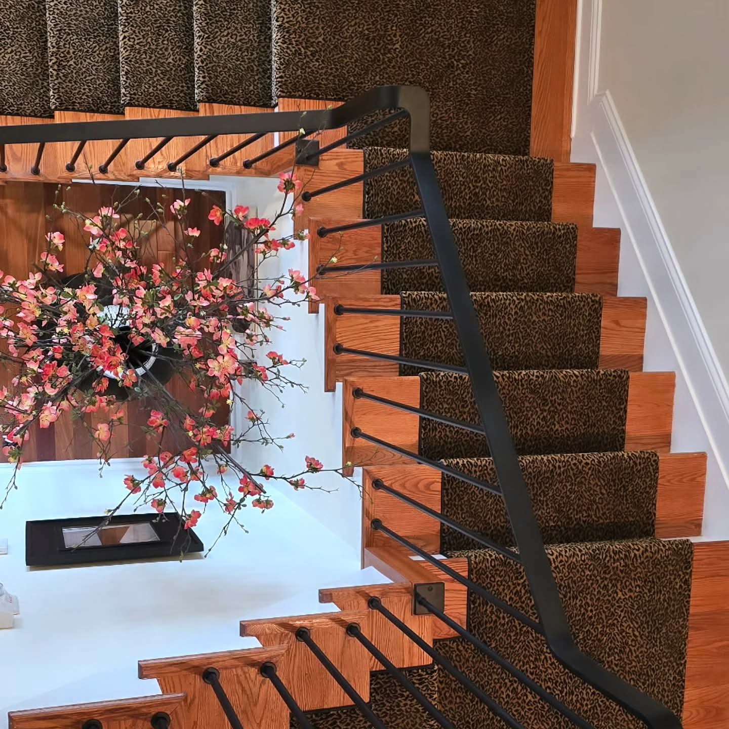 a staircase with a black railing and a flower pot a staircase with a black railing and a flower pot