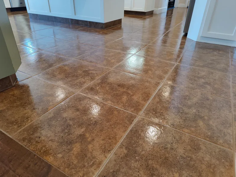 Close-up of a glossy, sealed brown tile floor with a protective coating