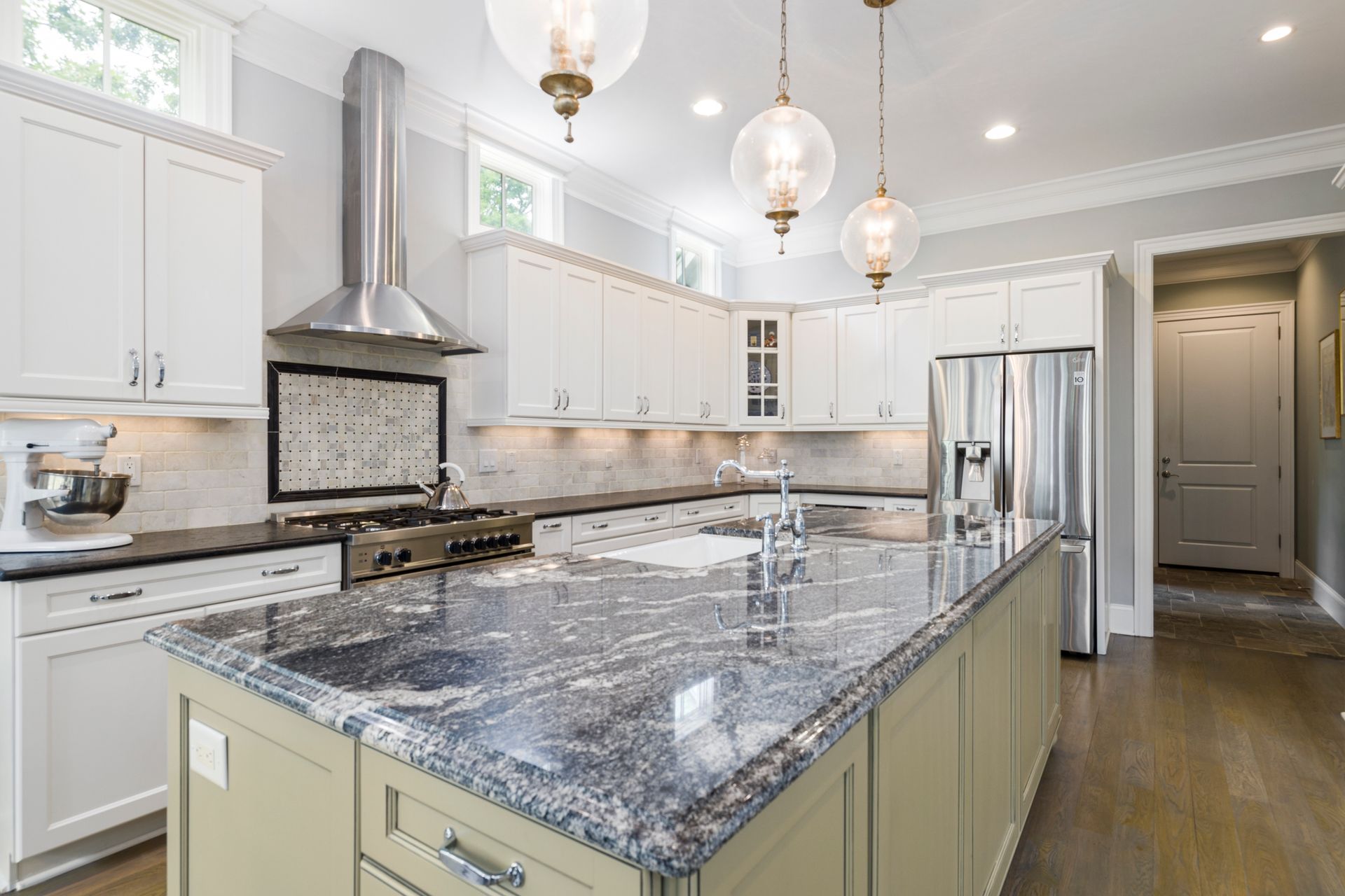 Kitchen with a blue-gray granite island countertop and white cabinetry Kitchen with a blue-gray granite island countertop and white cabinetry