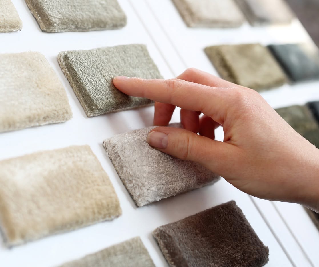 a hand touching a carpet sample a hand touching a carpet sample