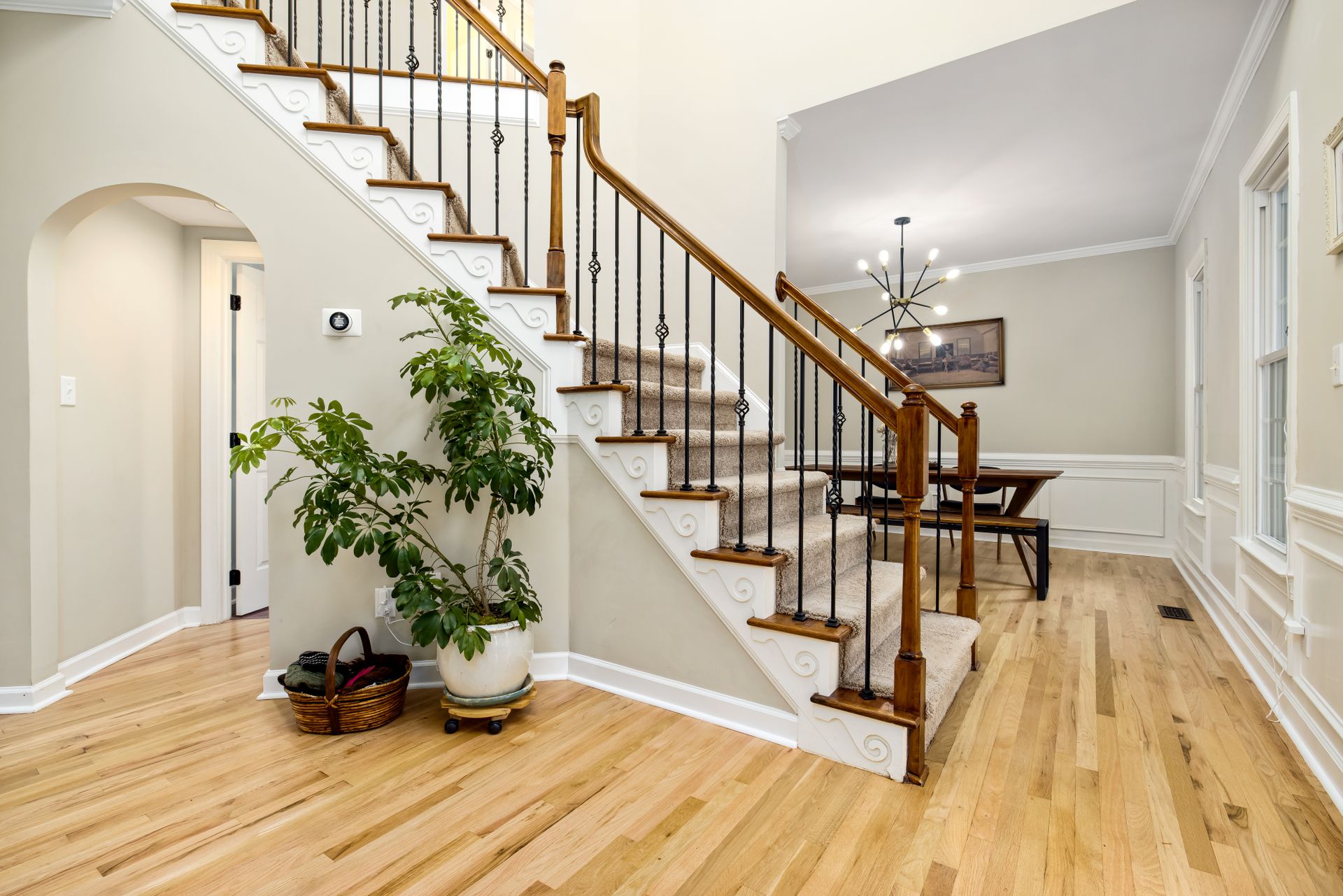 Entryway with a wooden staircase and light hardwood flooring Entryway with a wooden staircase and light hardwood flooring
