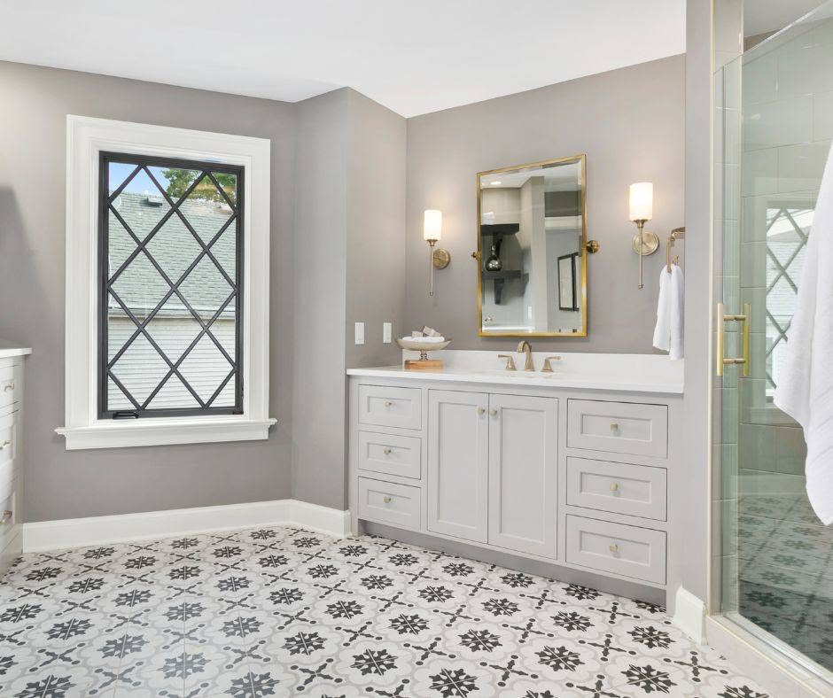 Bathroom with a white double vanity and a patterned black-and-white tile floor with clean grout